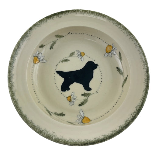 pasta plate in daisy pattern with black standing newfoundland dog.